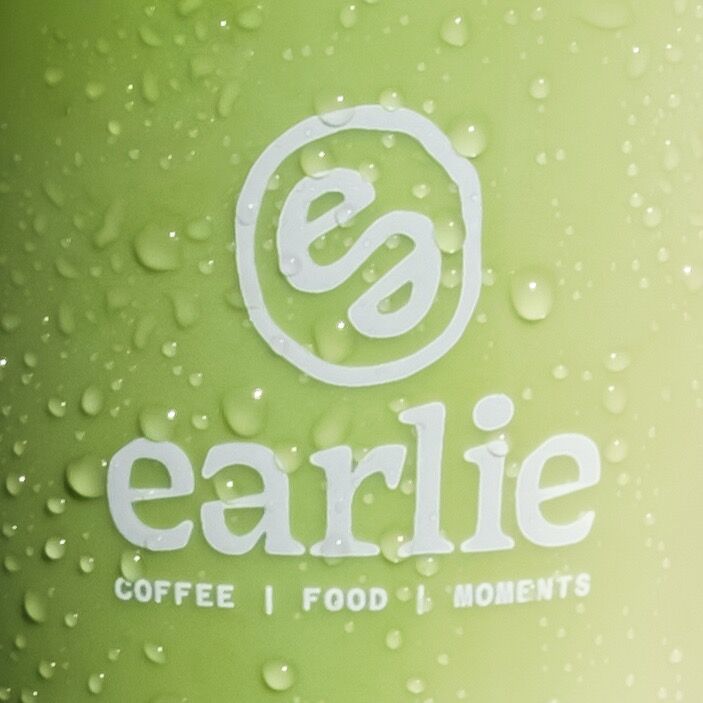 Un gobelet de matcha glacé couvert de gouttes, logo Earlie en blanc.